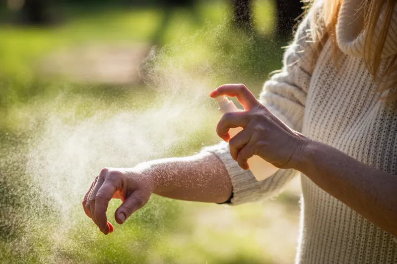 insect repellent woman tourist applying mosquito repellent on hand during hike in nature skin protection against tick and mosquito bite