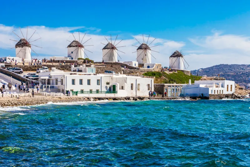two of the famous windmills in mykonos, greece during a clear and bright summer sunny day