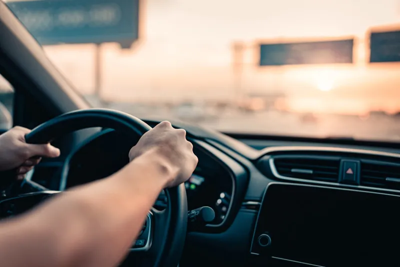 close-up - hand of man driving car on the road