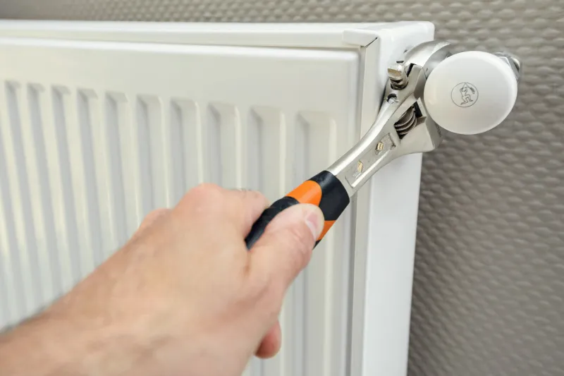 repair heating radiator with wrench, close-up view