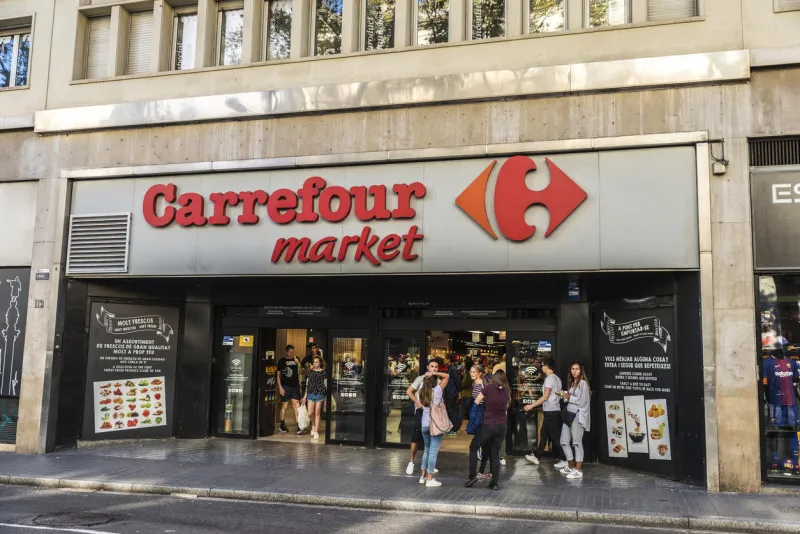 barcelona, spain - september 20, 2017  young tourists in front of a carrefour market in les rambles of barcelona, catalonia, spain