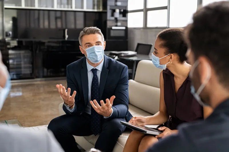 business people talking in meeting with face mask