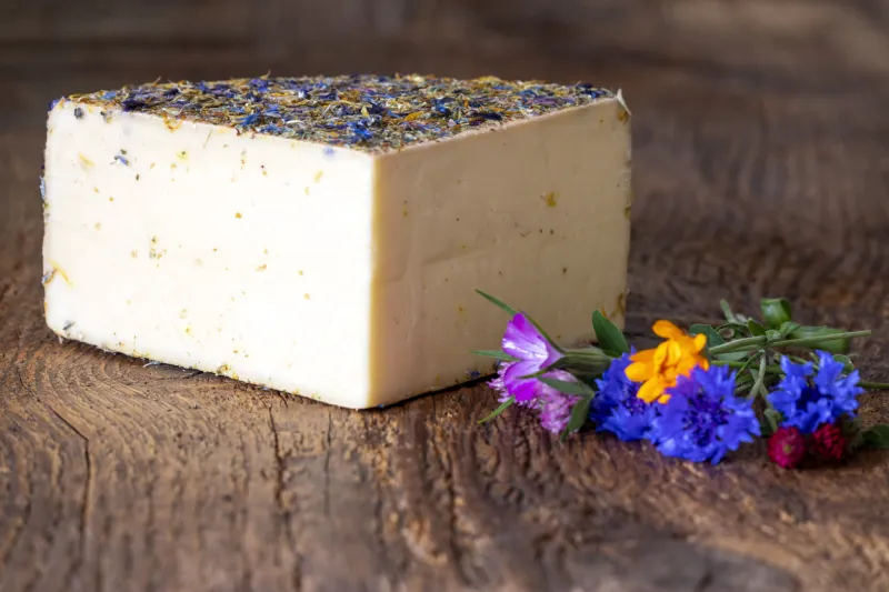 mountain cheese with flowers on wood