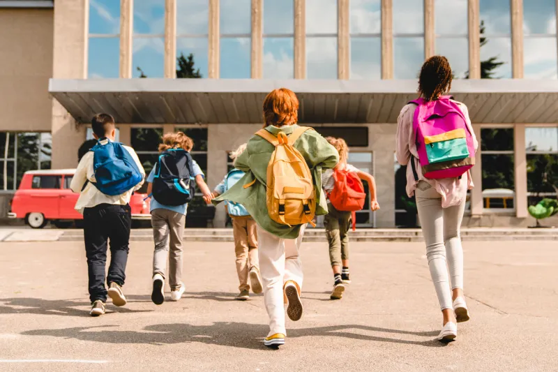 little kids schoolchildren pupils students running hurrying to the school building for classes lessons from to the school bus welcome back to school the new academic semester year start