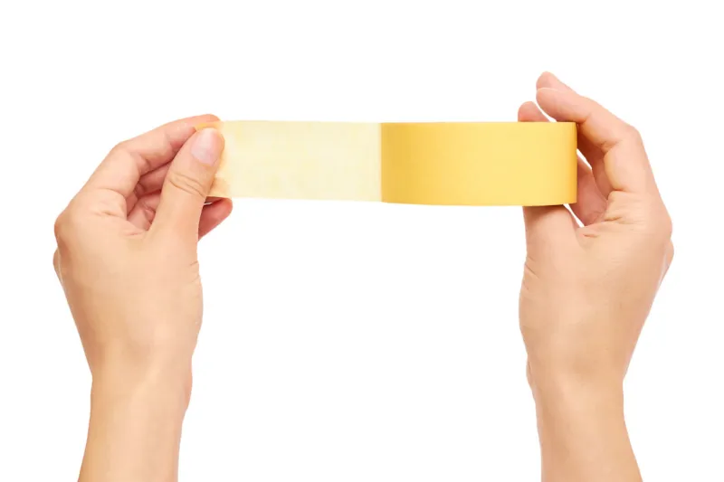 hands holding a yellow adhesive tape isolated on white background