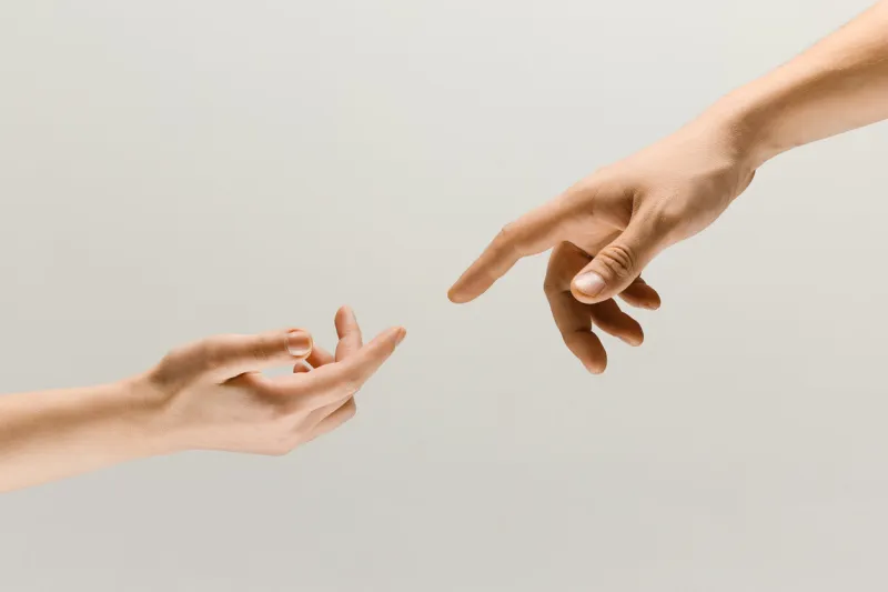 moment of weightless two male hands trying to touch like a creation of adam sign isolated on grey studio background concept of human relation, community, togetherness, symbolism, culture and history
