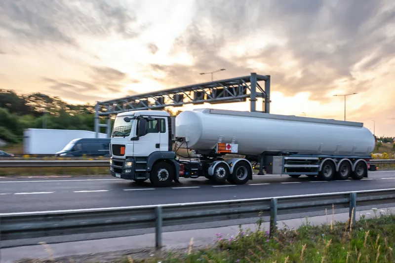 tanker truck in motion on the motorway with orange sky in the background