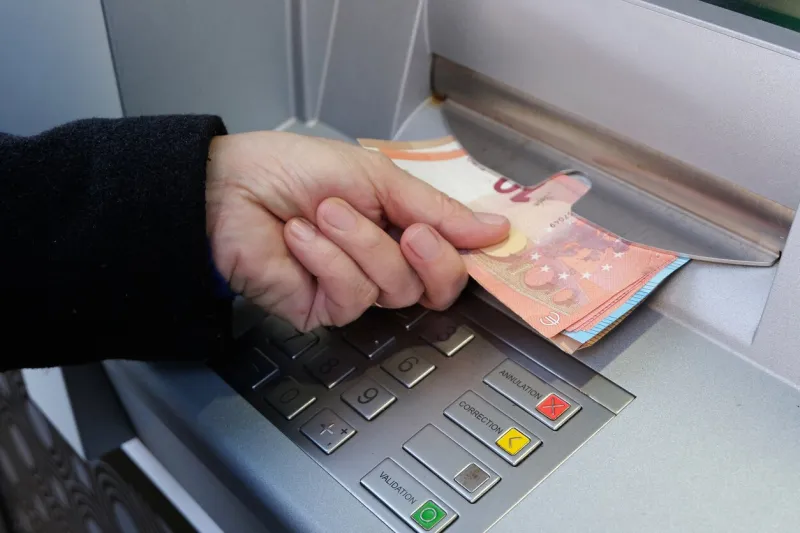 close-up of someone withdrawing euro banknotes from an atm