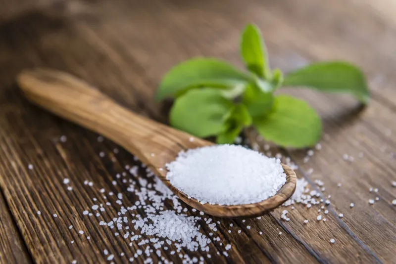 old wooden table with stevia granules (selective focus, close-up shot)
