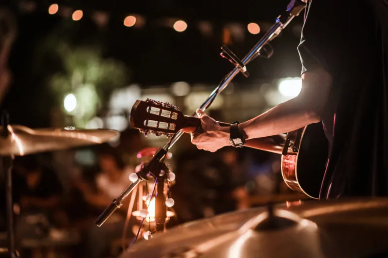 the musicians were playing rock music on stage, there was an audience full of people watching the concert concert,mini concert and music festivals