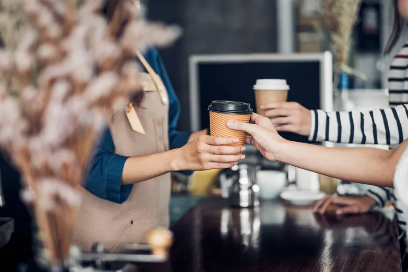 barista served take away hot coffee cup to customer at counter bar in cafe restaurant,coffee shop business owner concept,service mind waitress