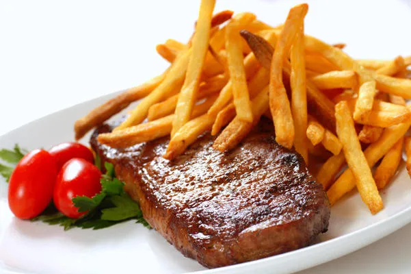 steak fraîchement poêlé avec des frites et des tomates