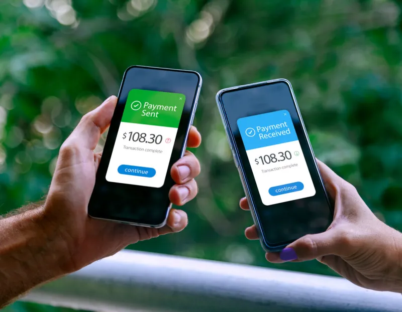 two smartphones held by a woman and a man showing sending and receiving payments through a digital wallet application on a mobile phone bank transfer concept digital money