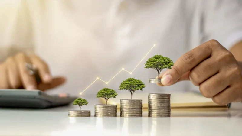 a businessman holding a coin with a tree that grows and a tree that grows on a pile of money the idea of maximizing the profit from the business investment