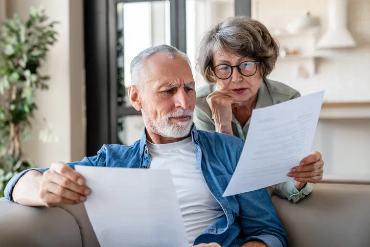 senior old elderly spouses grandparents reading documents, having issue problem debt with money loss, doing paperwork together at home mortgage, loan and commerce procedures