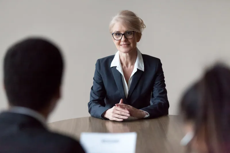 smiling middle aged senior female job applicant listening to hr questions making first impression at interview, recruiters interviewing older mature candidate, recruitment, age and employment concept