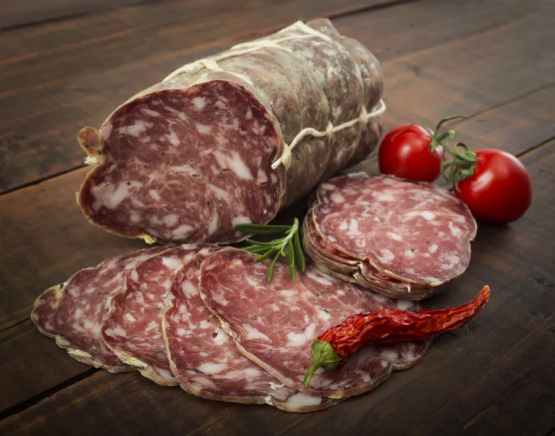 italian salami with red pepper cherry tomatoes on a wooden background