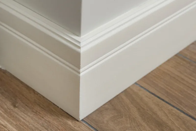 molding in the interior, baseboard corner light matte wall with tiles immitating hardwood flooring
