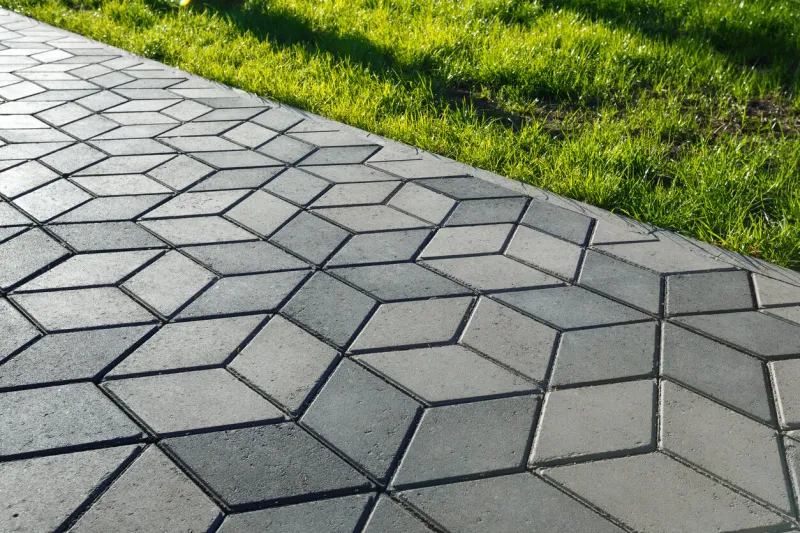 the footpath in the park is paved with diamond shaped concrete tiles