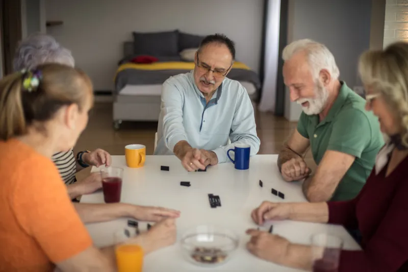 this game is a lot of fun senior people playing dominoes at home
