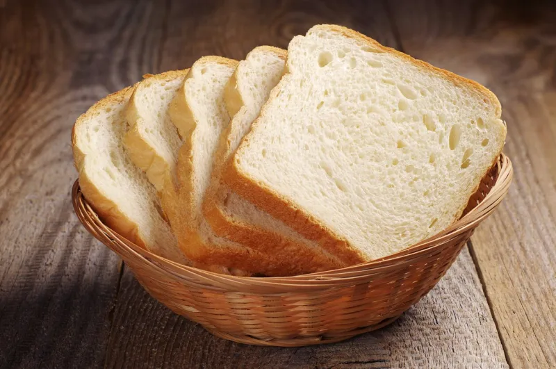 toast bread in wicker basket on old wooden table