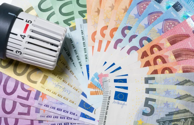 heating thermostat with money, expensive heating costs concept