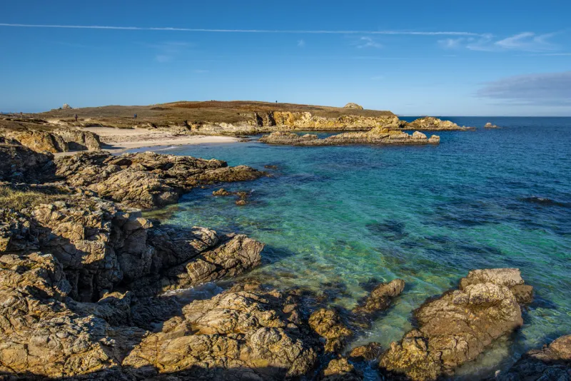 the view of rocky coastline and sandy beach in northwestern part of hoedic island, the cape of vieux chateaux is at background brittany, france