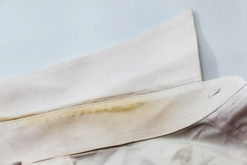 yellow collar stain on white dirty shirt