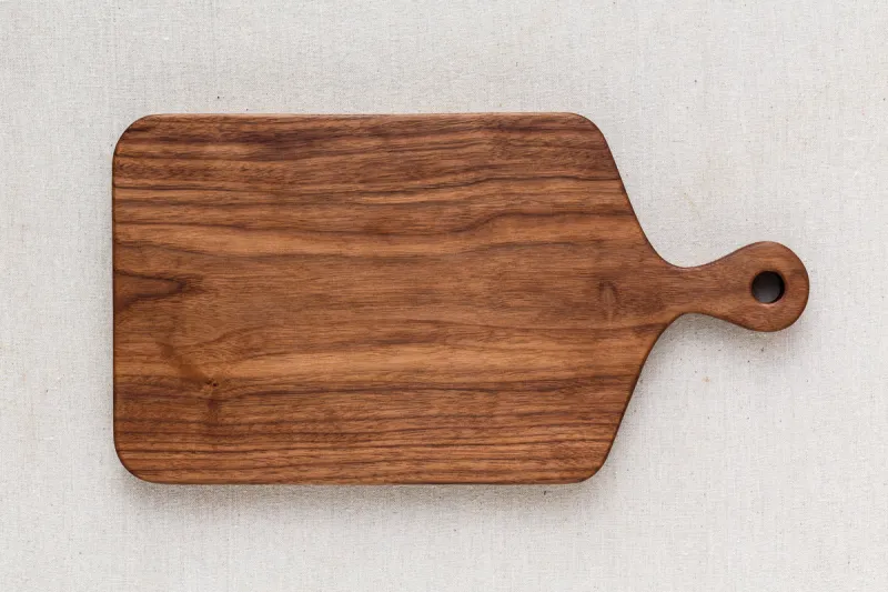 walnut handmade wood cutting board on the linen
