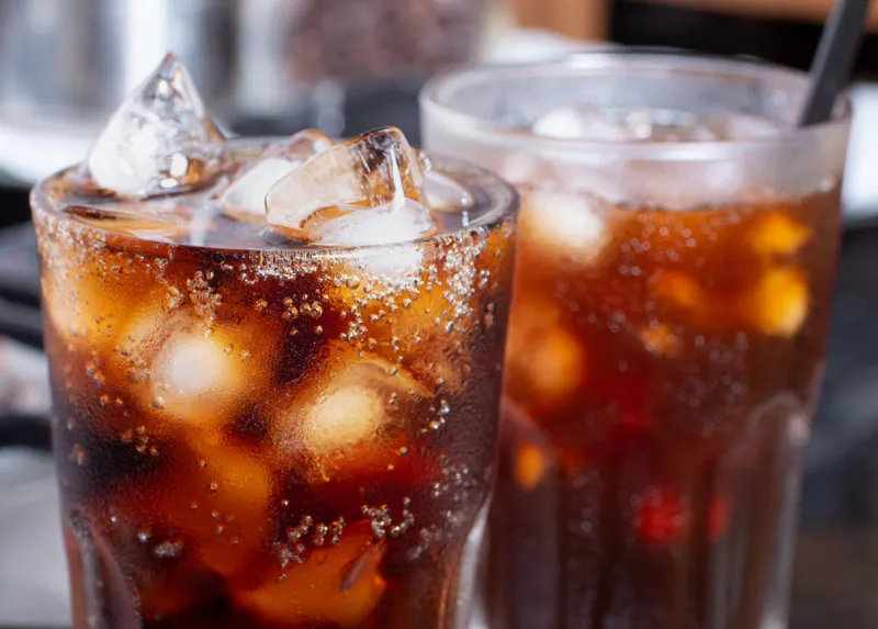 cola with crushed ice in glass and there is water droplets around cool black fresh drink