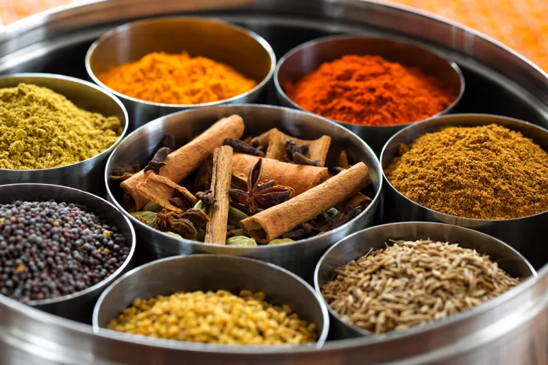 whole and ground spices neatly organized in a metal tin