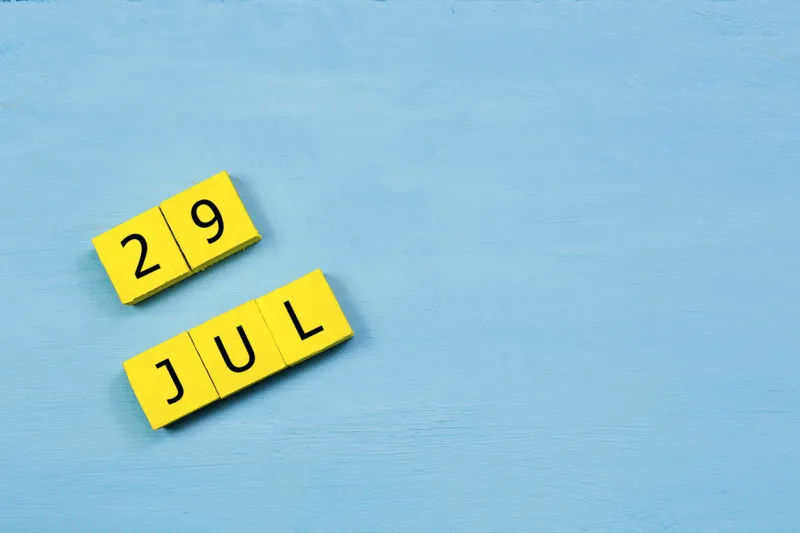 jul 29, yellow cube calendar on blue wooden surface with copy space