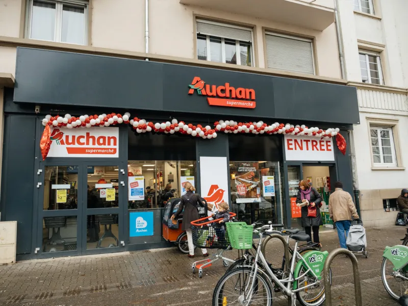 strasbourg  auchan supermarket entrance in french neighborhood on a winter snow day with customers exiting the entrance of the store