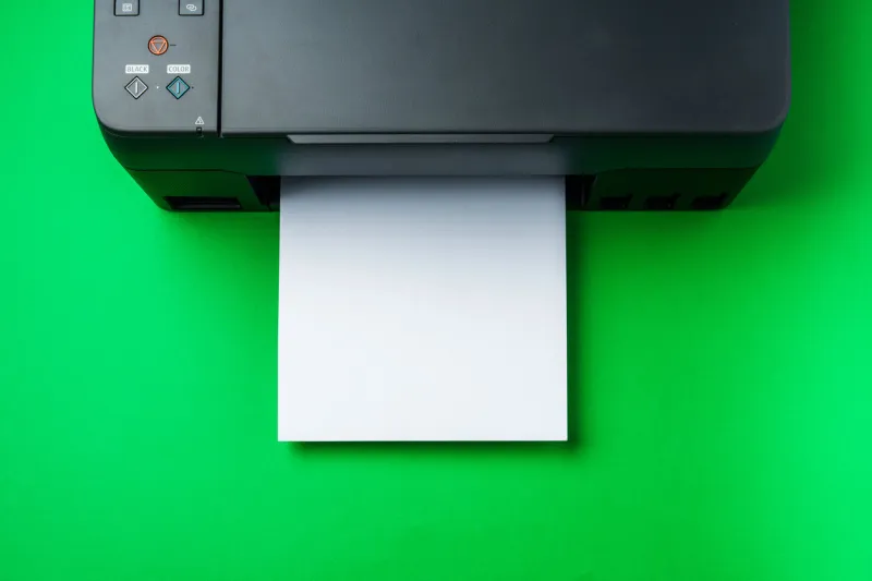 modern printer with paper on green background close up