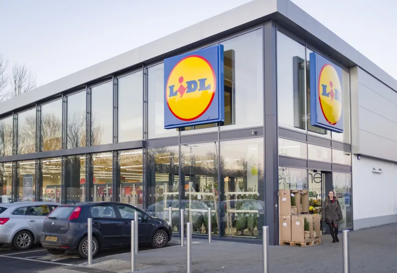 buckingham, uk - december 04, 2019 lidl supermarket store exterior, with woman shopper outside the entrance