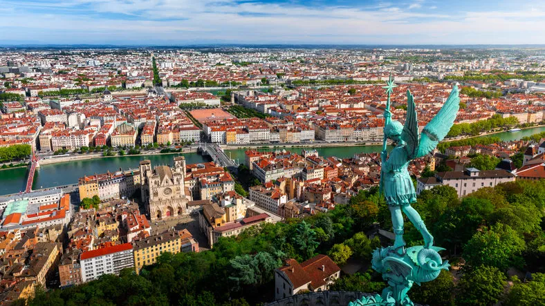 awesome aerial view on lyon french cityscape viewed from the roofs of basilica notre dame de fourviere with archangel michael statue overlooking the city