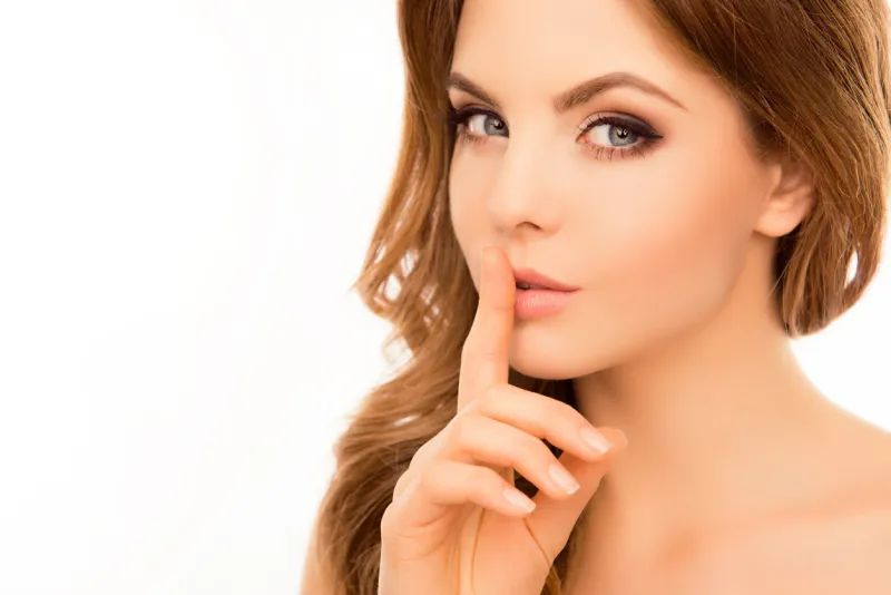 pretty woman having secret and holding finger on lips