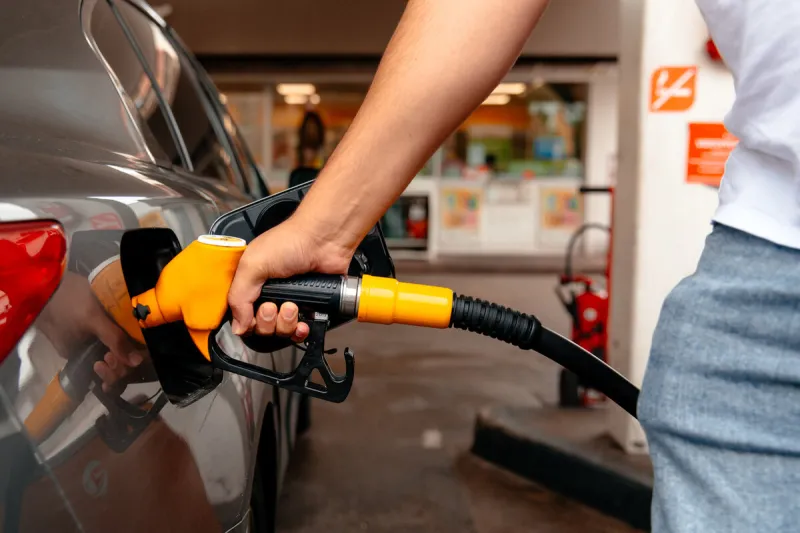 young man, fill diesel tank of car after finish refill diesel oil and pay price with tax in gas station for transportation of his travel