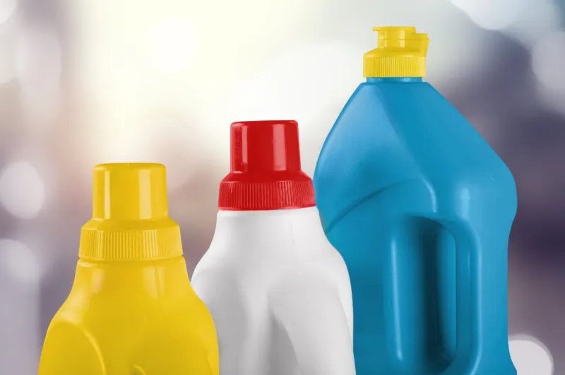plastic bottle with household chemicals on light background