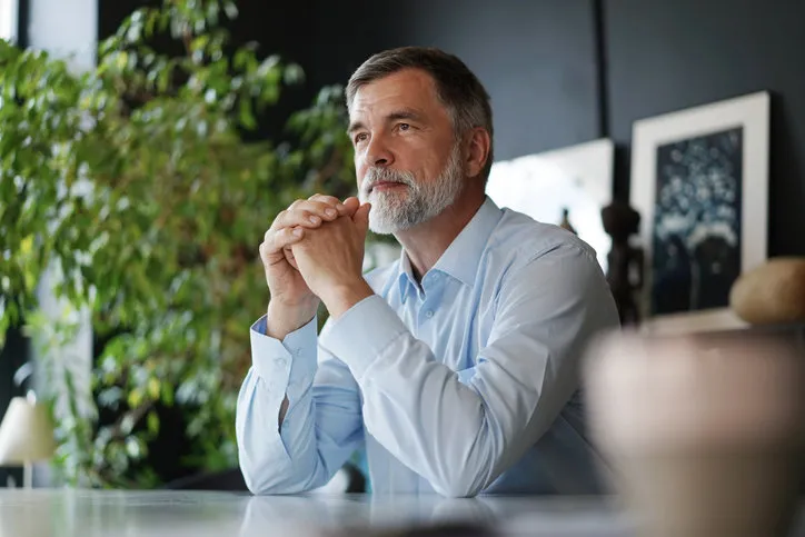 portrait mature professional businessman with grey hair smiling confident adult entrepreneur, leader, manager sitting in office