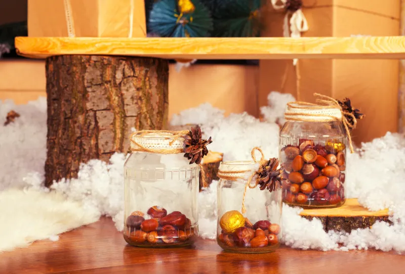 decoration from glass jars with acorns and chestnuts and synthetic snow