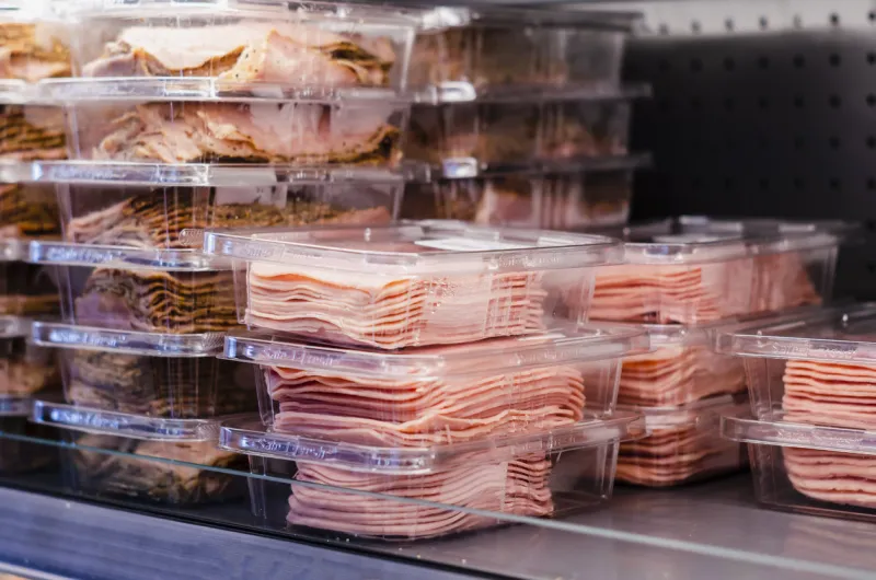 ham packed and stacked on supermarket shelves for sale retail