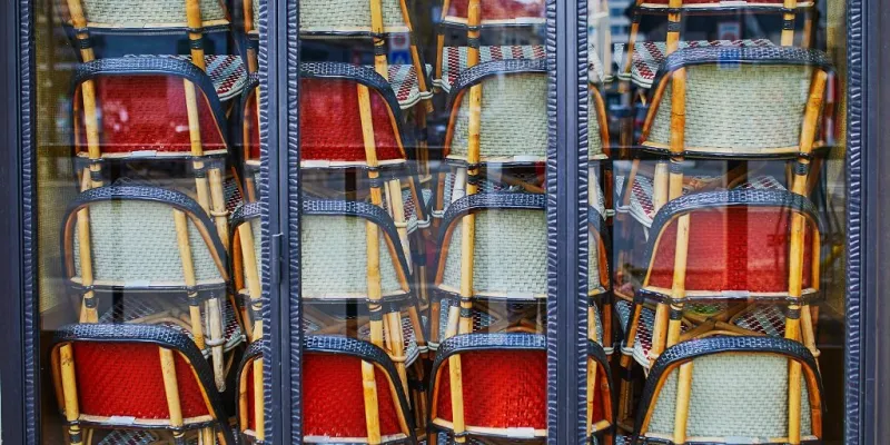 tables and chairs piled up in closed parisian restaurants and cafes during outbreak of coronavirus covid-19 quarantine and social distancing concept