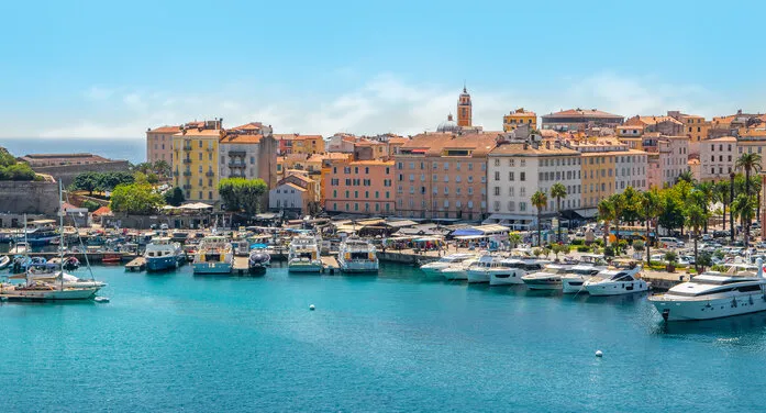 bright image with boats and yachts in the harbor of ajaccio, corsica island, france colorful buildings in the city along the waterfront blue sky on a summer day cruise destination panoramic landscape view