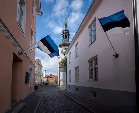 street with estonian flags and st marys cathedral at toompea hill - tallinn, estonia
