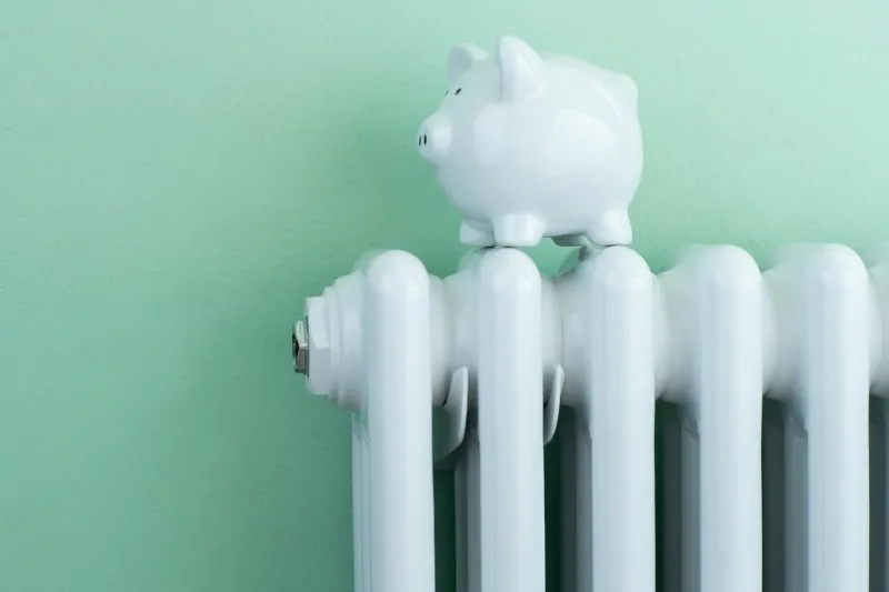 piggy bank balanced on radiator to illustrate energy costs