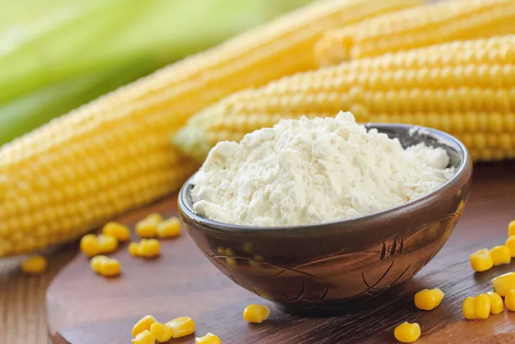 corn flour in a bowl and corn cob on the table