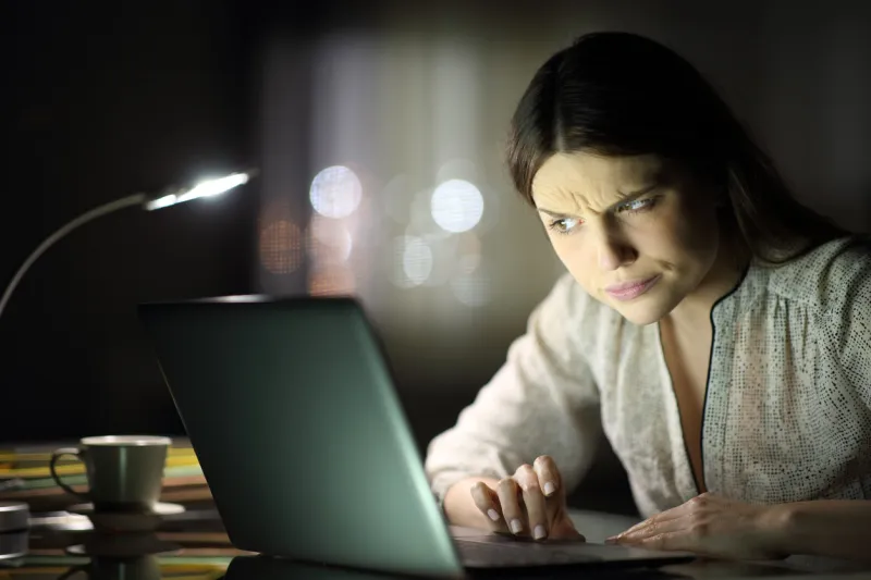 suspicious woman checking laptop content in the night