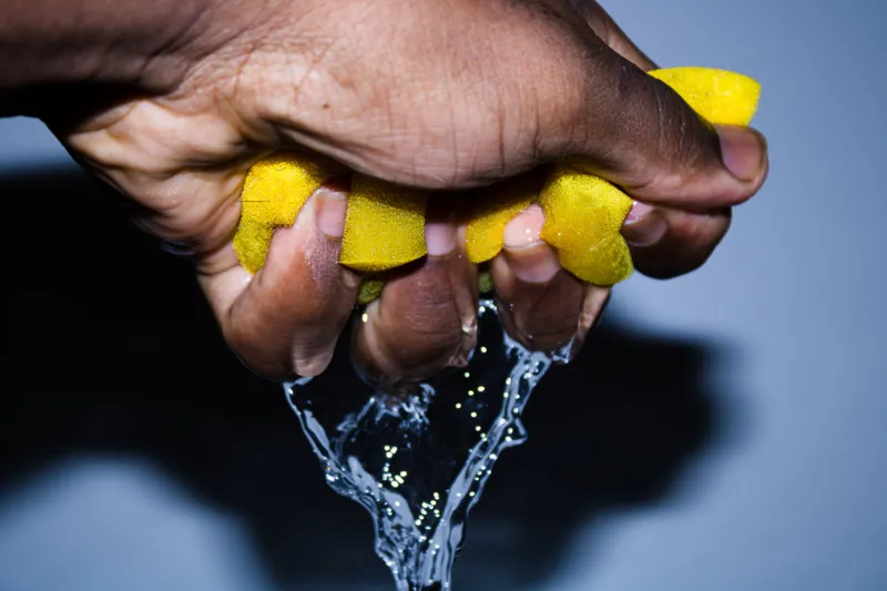 squeezing a wet sponge in a bright background