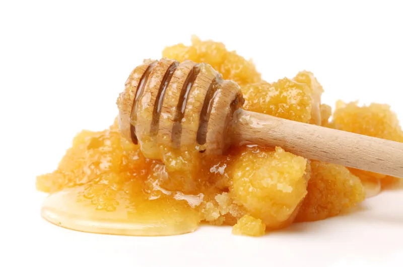 naturally crystallized rape honey on white wooden